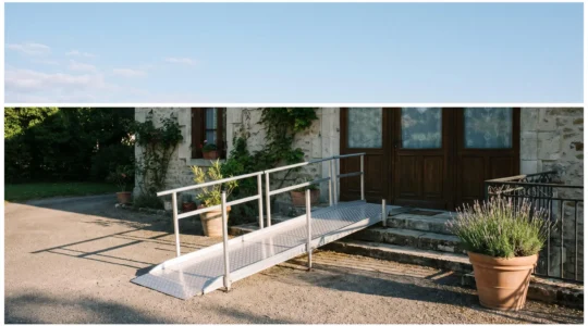 Rampe d'accès en aluminium installée devant trois marches d'entrée d'une maison française pour permettre le passage d'un fauteuil roulant